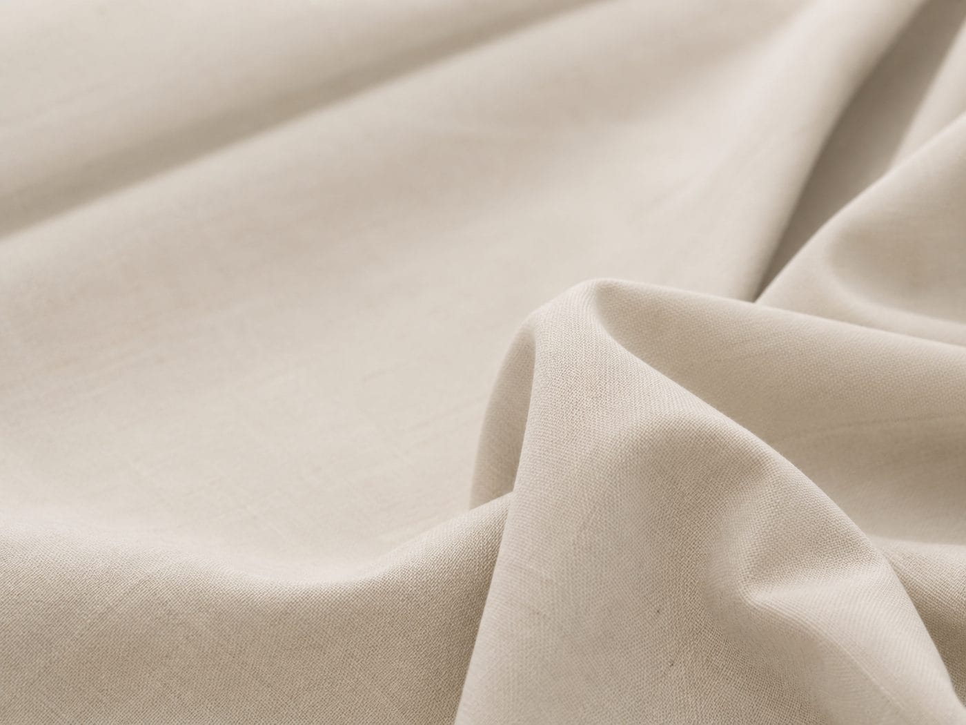 Loom-state greige cotton in its natural off-white colour, roll and draped folds